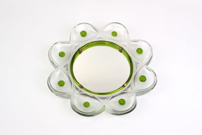 a glass plate with green dots on it on a white surface