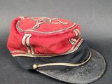 un chapeau rouge et noir posé sur une table noire