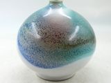 un vase bleu et blanc posé sur une surface blanche