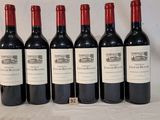 six bottles of wine are lined up on a table