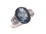 gros plan d'une bague avec une pierre bleue et des diamants