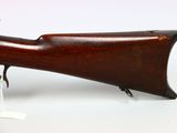 a close up of a rifle on a white surface with a tag