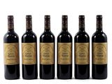 six bottles of wine are lined up on a white surface