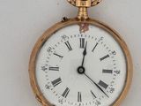a gold pocket watch with roman numerals on the face