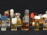many different types of perfume bottles lined up on a black surface
