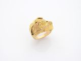 gros plan d'une bague en or sur une surface blanche