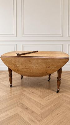 une table ovale en chêne à abattants, avec des pieds tournés
