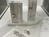 two pieces of jewelry on display in a glass case