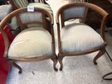 pair of antique chairs with upholstered cushions in a store