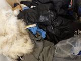 a dog that is laying down in a pile of clothes