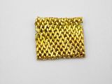 a close up of a gold bracelet on a white surface