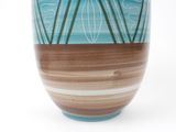 a blue and brown vase sitting on a white surface