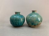 two blue vases sitting on top of a table next to each other
