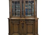 a large wooden china cabinet with glass doors and drawers