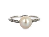 bague en perles blanches et diamants sur fond blanc