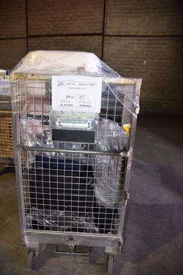 a cage with a mattress on top of it in a warehouse