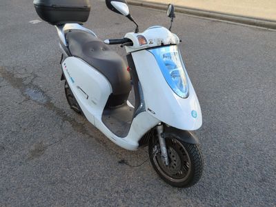 un scooter blanc garé sur le bord de la route