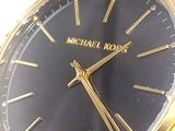 a black and gold watch on a black leather strap