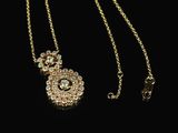 a gold plated necklace with a flower design on a chain