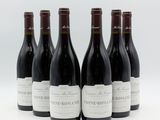 six bouteilles de vin sont alignées sur une surface blanche