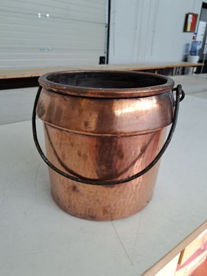 un grand chaudron en cuivre posé sur une table dans un entrepôt