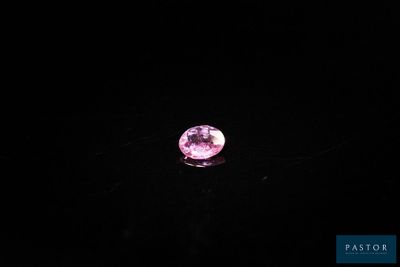 gros plan d'un diamant rose sur une surface noire