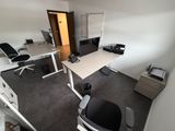 vue en plan d'un bureau avec un bureau, une chaise et un écran d'ordinateur