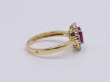 a close up of a gold ring with a ruby stone