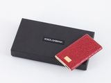 un portefeuille rouge posé à côté d'une boîte noire sur une surface blanche