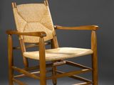 une chaise en bois avec une assise tressée sur fond gris