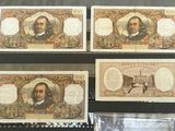four different types of paper money are on display in a glass case