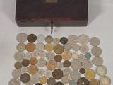 a small wooden box filled with coins on a white surface