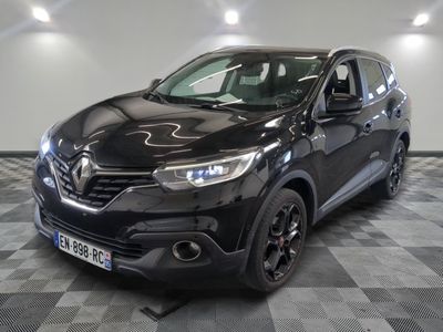 la voiture noire est garée sur un sol en damier dans le garage