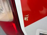 a close up of a red and white car with a cat on the side of it