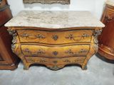 une commode au plateau en marbre, placée à côté d'un miroir