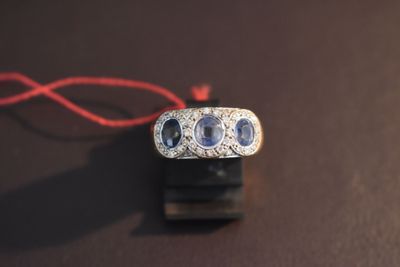 a ring with three blue sapphires on it on a table