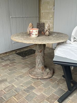 une petite table sur laquelle se trouve un vase, sur la terrasse