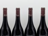 six bottles of wine are lined up in a row on a table