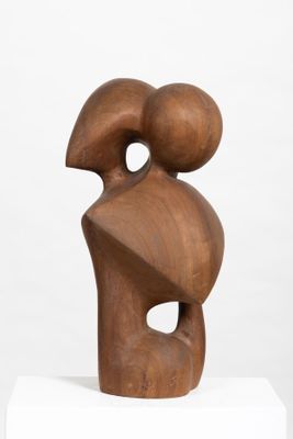 a close up of a wooden sculpture on a white pedestal