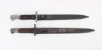 two old knives are sitting side by side on a white surface