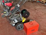 several lawn mowers are lined up in a garage