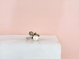 une bague en perle posée sur un bloc blanc
