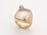a close up of a gold ring with a white stone and a diamond