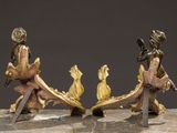 pair of bronze figurines of a man and a woman with a sword