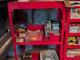 a red shelving with many items on it in a garage