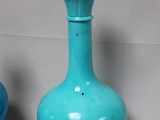 two blue vases sitting next to each other on a table