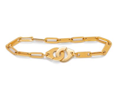 gros plan d'un bracelet en chaîne en or sur fond blanc