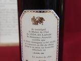 une bouteille de vin posée sur une table, avec un livre en arrière-plan