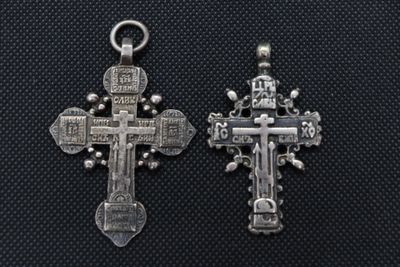 two silver crosses on a black background with a cross in the middle