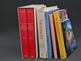 plusieurs livres sont empilés sur une surface grise